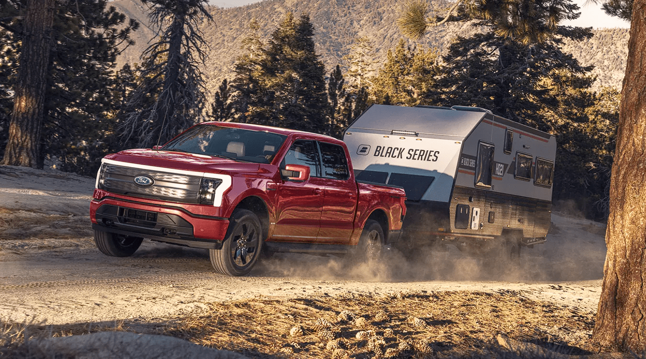 Ford F-150 Lightning towing a trailer in the woods
